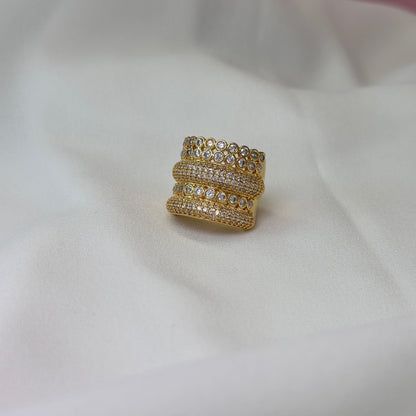Anel dourado cravejado, com pontos de zircônia